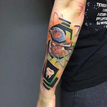 Eisenherz Tattoo und Piercing Magdeburg - Modernes Abstract Tattoo am Unterarm mit Vogelmotiv, geometrischen Formen und farbigen Flächen. Künstlerisches Arm Tattoo für Keywords wie Vogel Tattoo, Abstract Tattoo, Geometric Tattoo, Color Tattoo und mo...