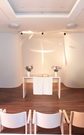 Die Lichtinstallation des Künstlers Dieter Detzner lässt das Kreuz in der Kapelle strahlen.
