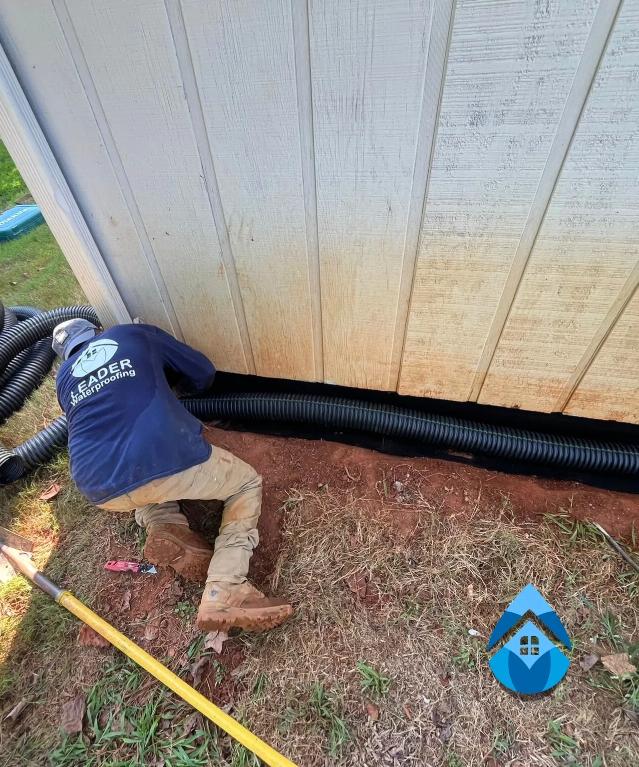 Close-up view of a vertical foundation crack being repaired using gray waterproof sealant. The repair helps prevent water infiltration through damaged concrete foundation walls.