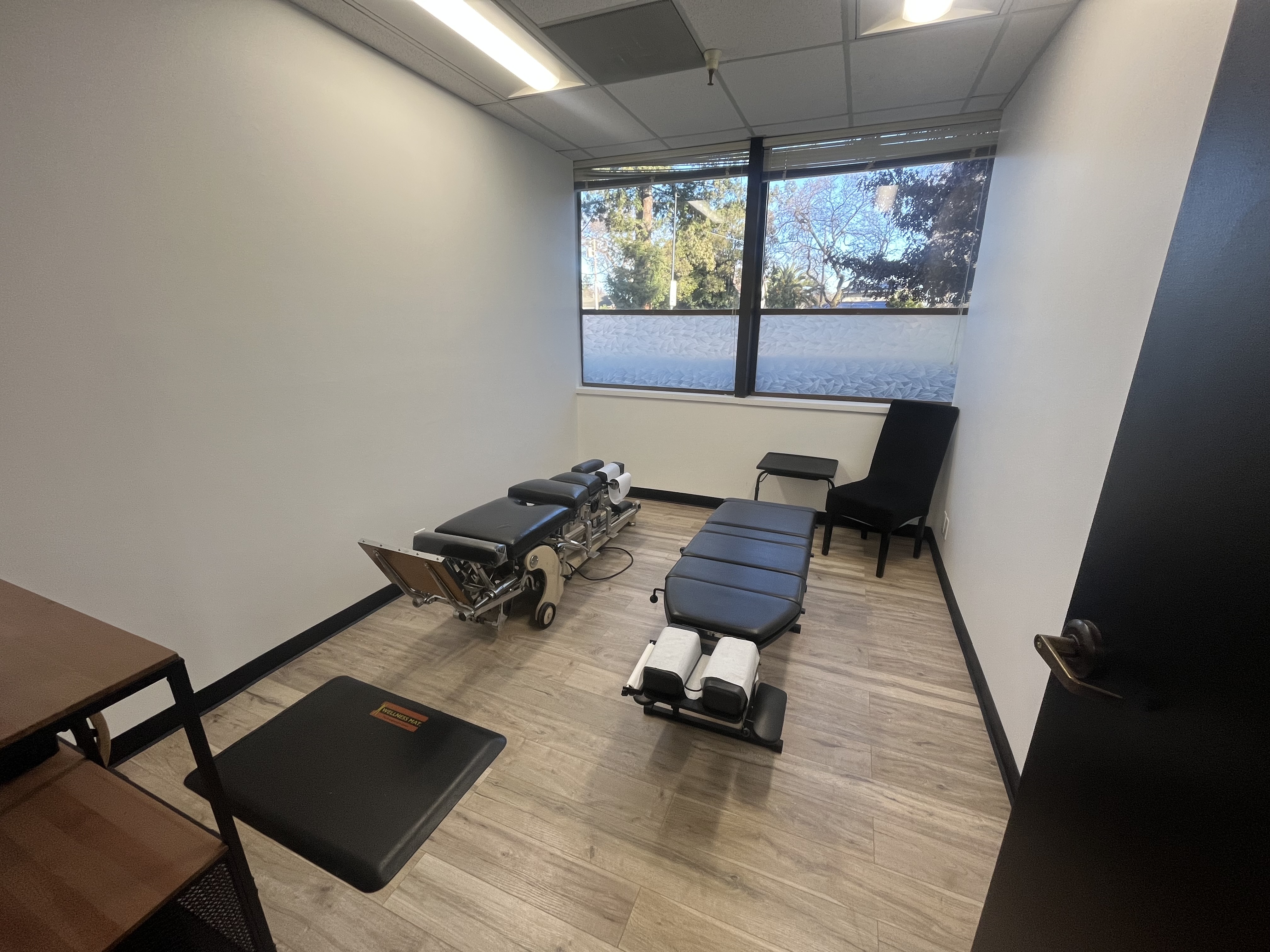 Private chiropractic treatment room featuring two comfortable tables.