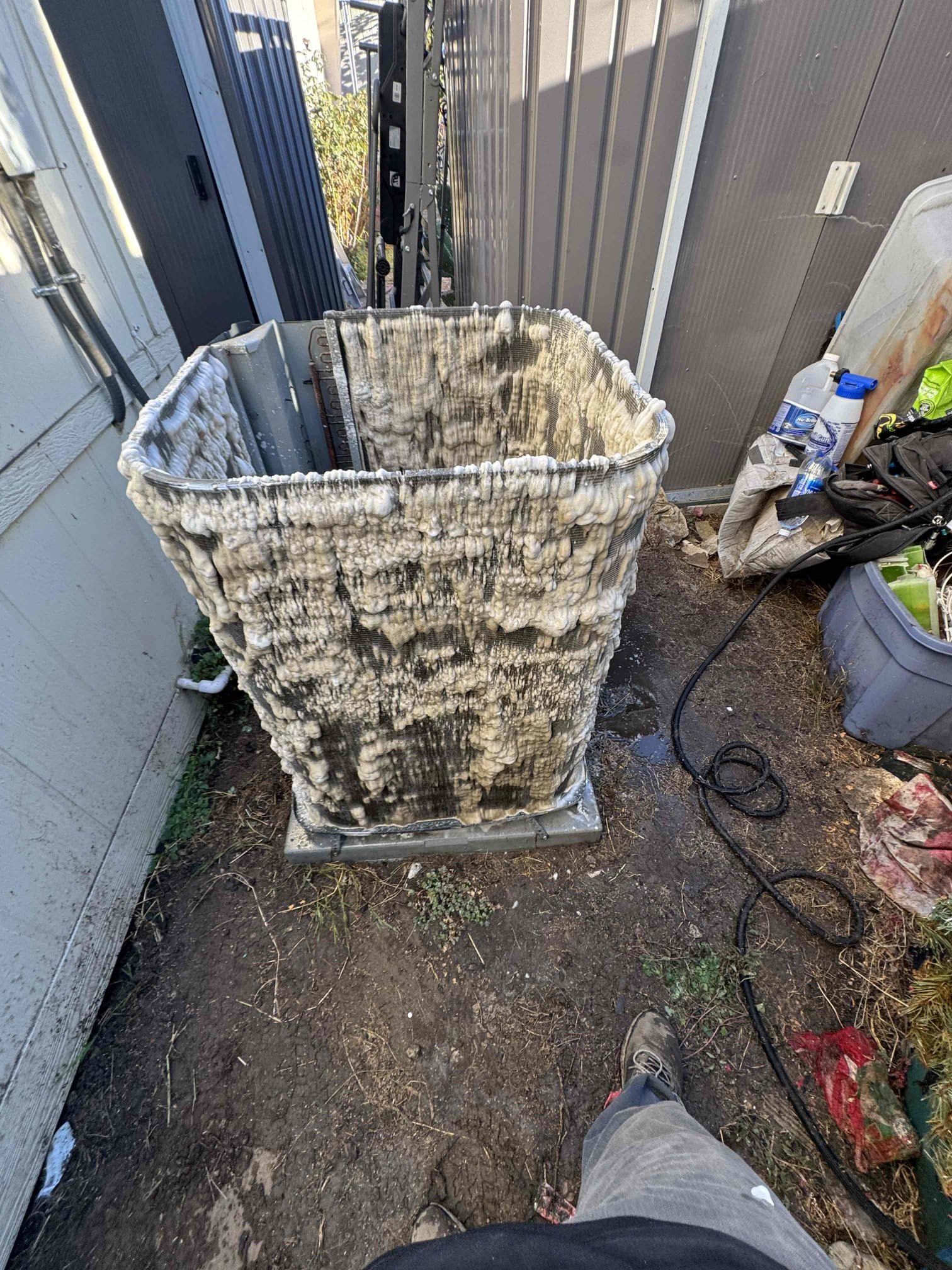 A heavily clogged and deteriorated AC condenser coil removed from a residential unit, showing years of dirt and debris buildup — before being replaced by Affordable Heating and Air.