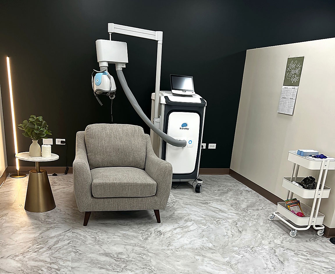 TMS treatment room at Transcend Functional Health in Greenwood Village, featuring BrainsWay Deep TMS technology and a comfortable patient seating area.
