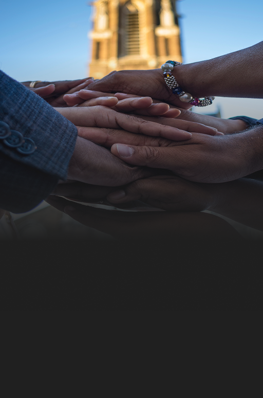A close up of team members with their hands stacked on top of each other's.