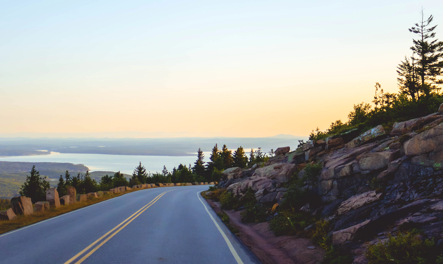Winding road with a scenic sunrise view.