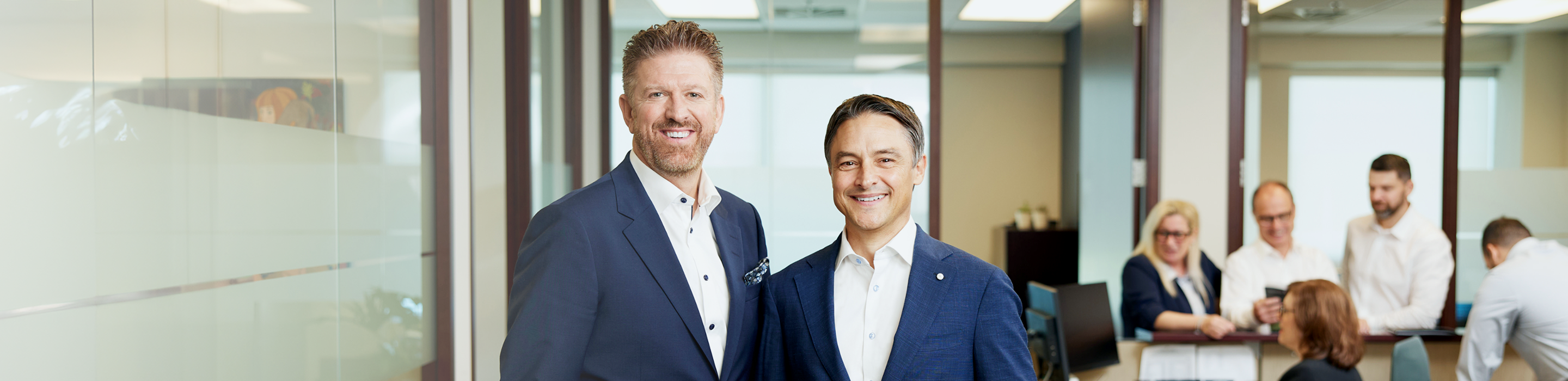 Jean Marchand and Patrice Filiatrault posing with their team in the background.
