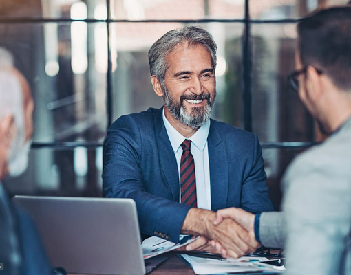 A suited professional shaking hands with someone.