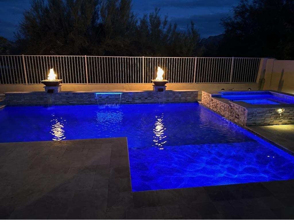 ✨ Luxury Pool Remodel with Fire & LED Lighting in Scottsdale – Evening View ✨

This breathtaking nighttime view showcases a Scottsdale pool remodel with stunning fire and water features. The custom spillways create a tranquil waterfall effect, while the fire pots surrounding the spa add warmth and elegance. Vibrant LED lighting enhances the pool’s modern design, creating a resort-style atmosphere perfect for evening relaxation. This high-end backyard transformation blends luxury and ambiance for the ultimate outdoor retreat.