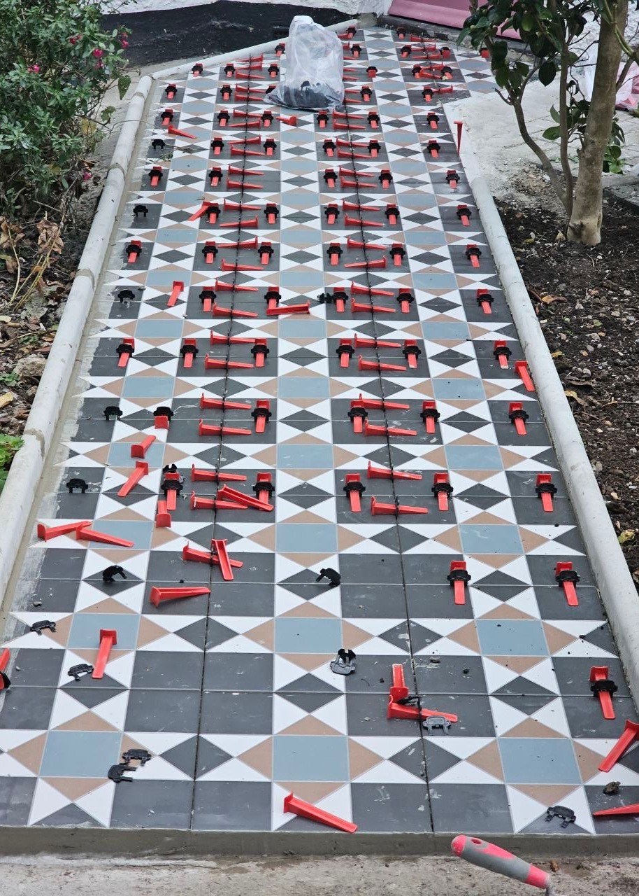 A beautifully aligned geometric tile pathway in progress. This image highlights precision, pattern accuracy, and Ercon’s commitment to exterior aesthetics that blend seamlessly with landscaping.