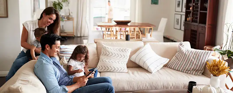 young-hispanic-family-sitting-on-sofa-reading-a-book