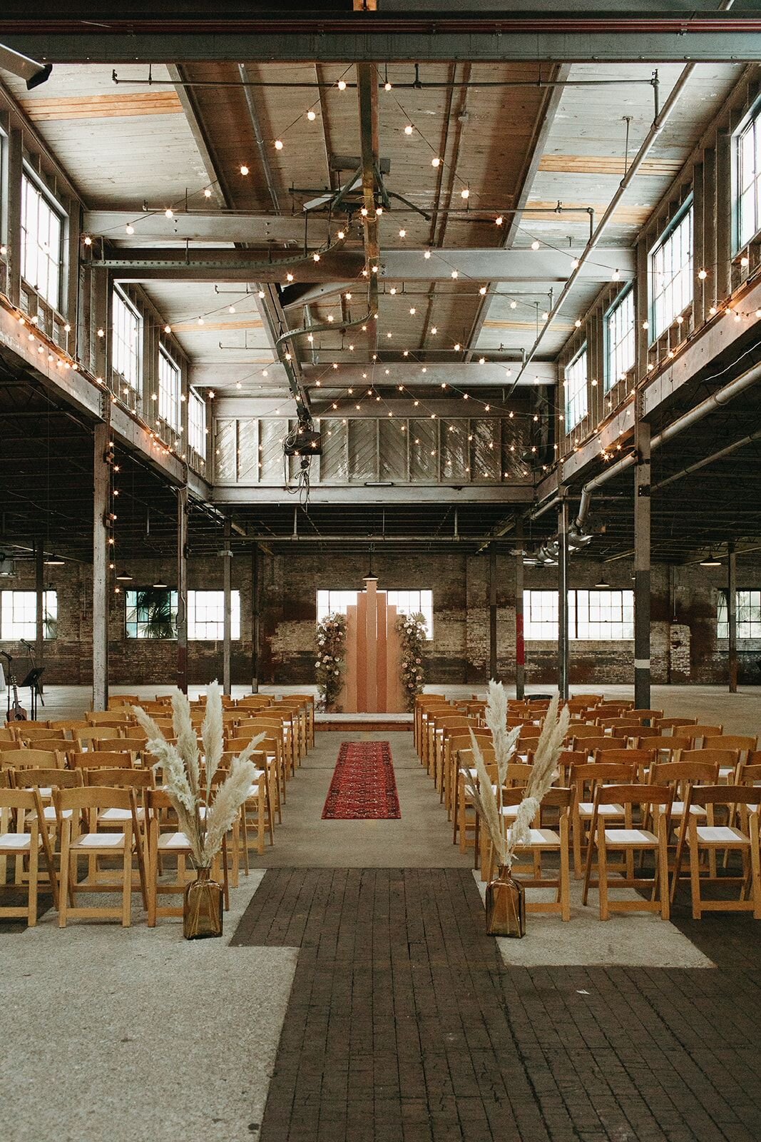 Indoor wedding ceremony setup inside The Glass Factory’s industrial event hall.