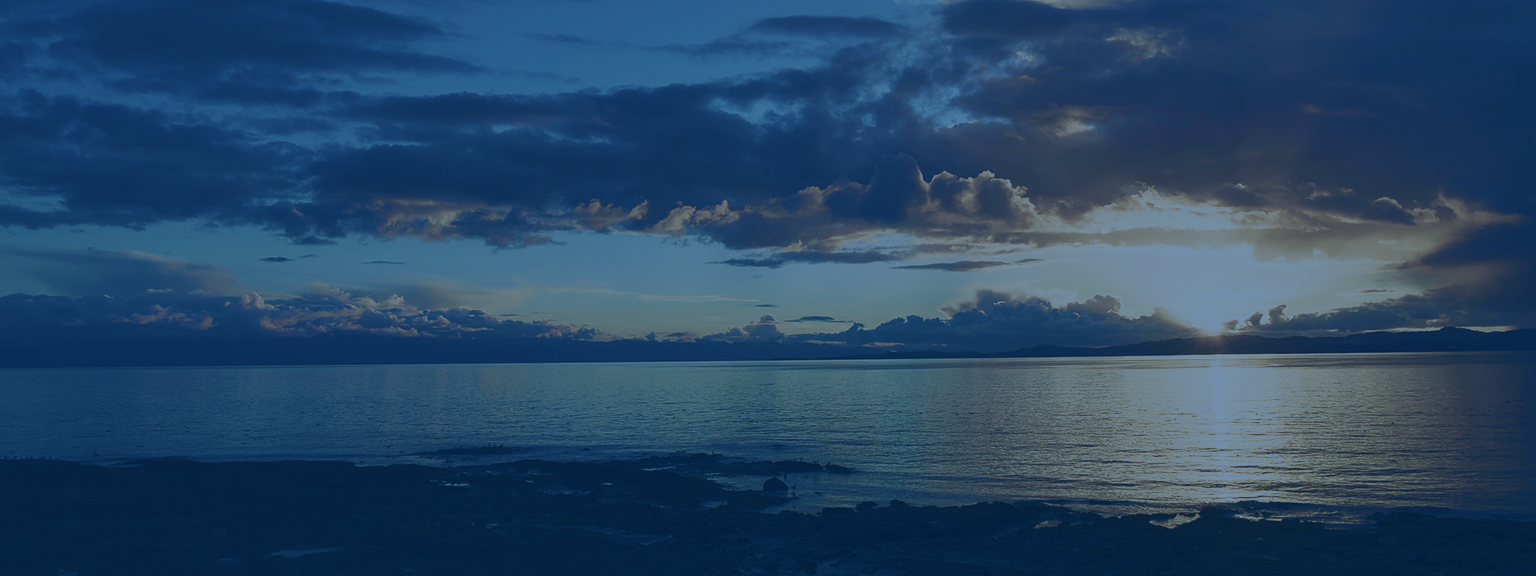 Sunrise over a lake on a partly cloudy morning.