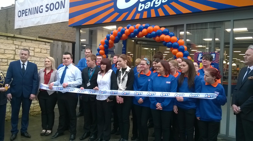 Staff pose outside B&M's latest store at the opening ceremony in Bicester.