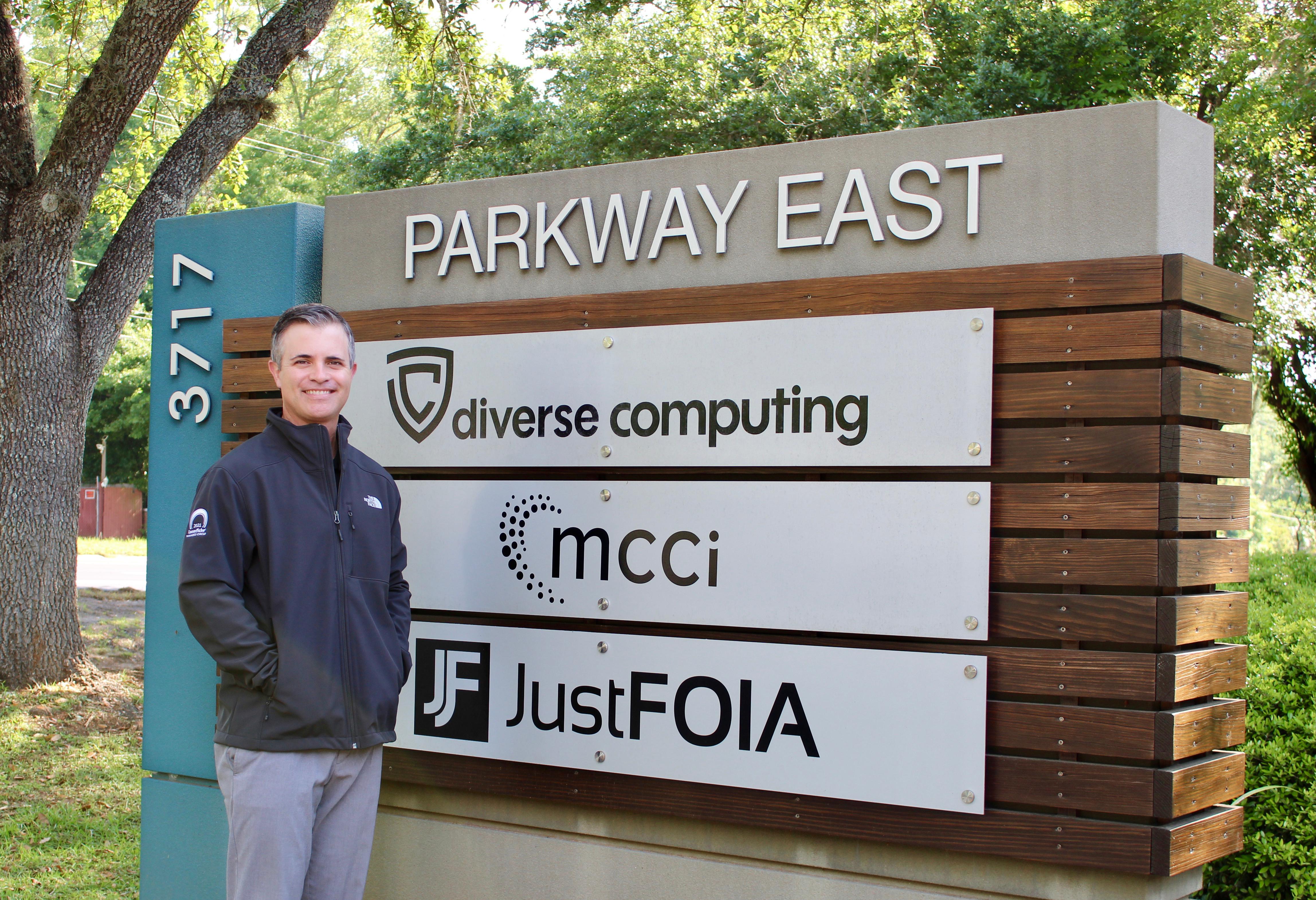 President & CEO, Donny Barstow, wearing his Laserfiche Winners Circle jacket by our company sign.