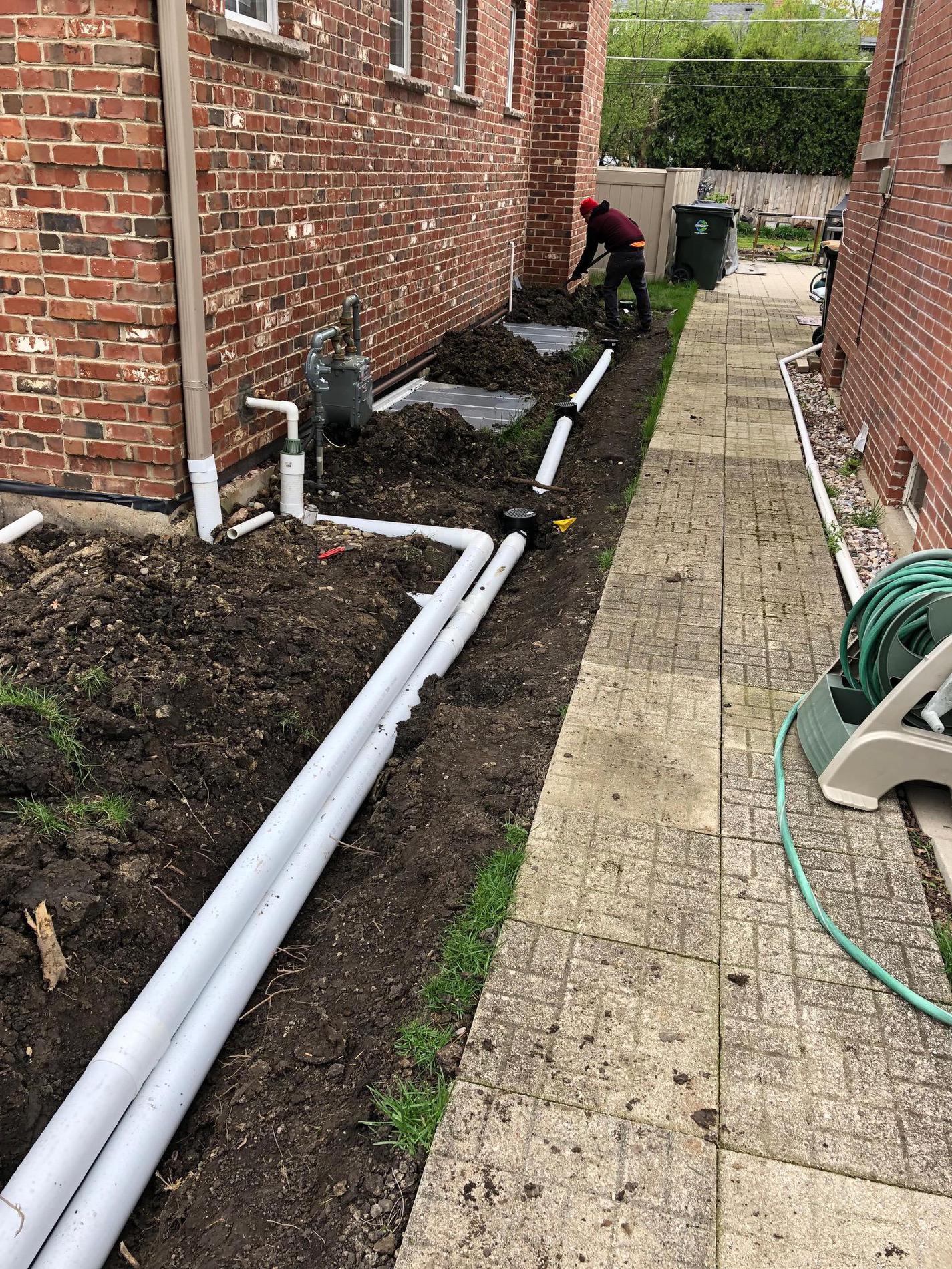 Drainage work in Park Ridge. Installed three catch basins to remove water accumulation on the side of the house. Connected sump to a pop up drain in front yard