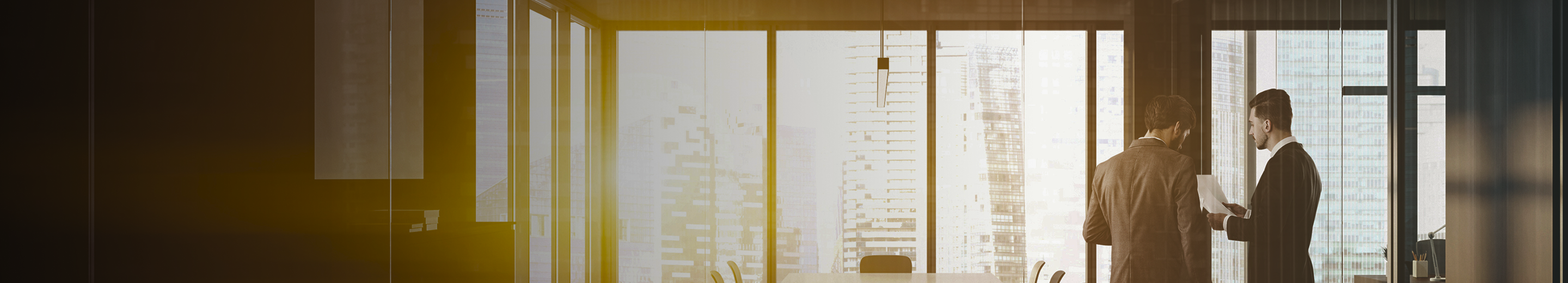 Two professionals having a discussion in an office boardroom.