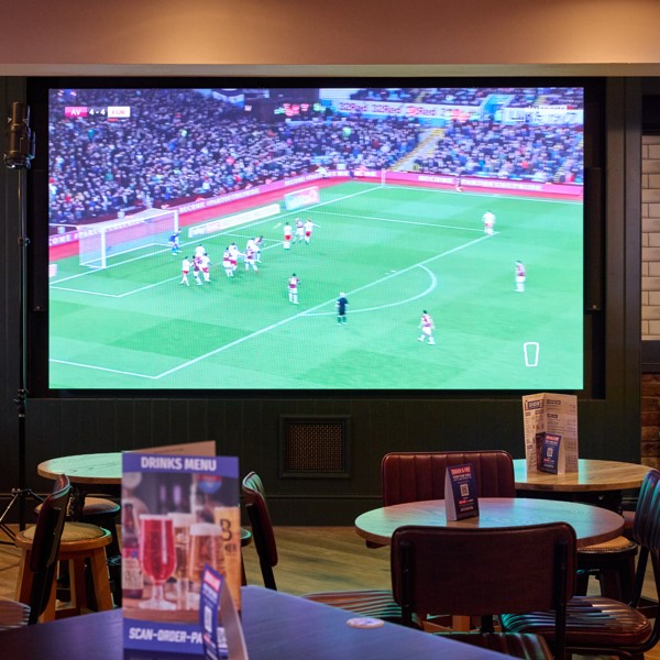 Large sports viewing area at The Tollgate with comfortable seating and a giant screen showing live sport.