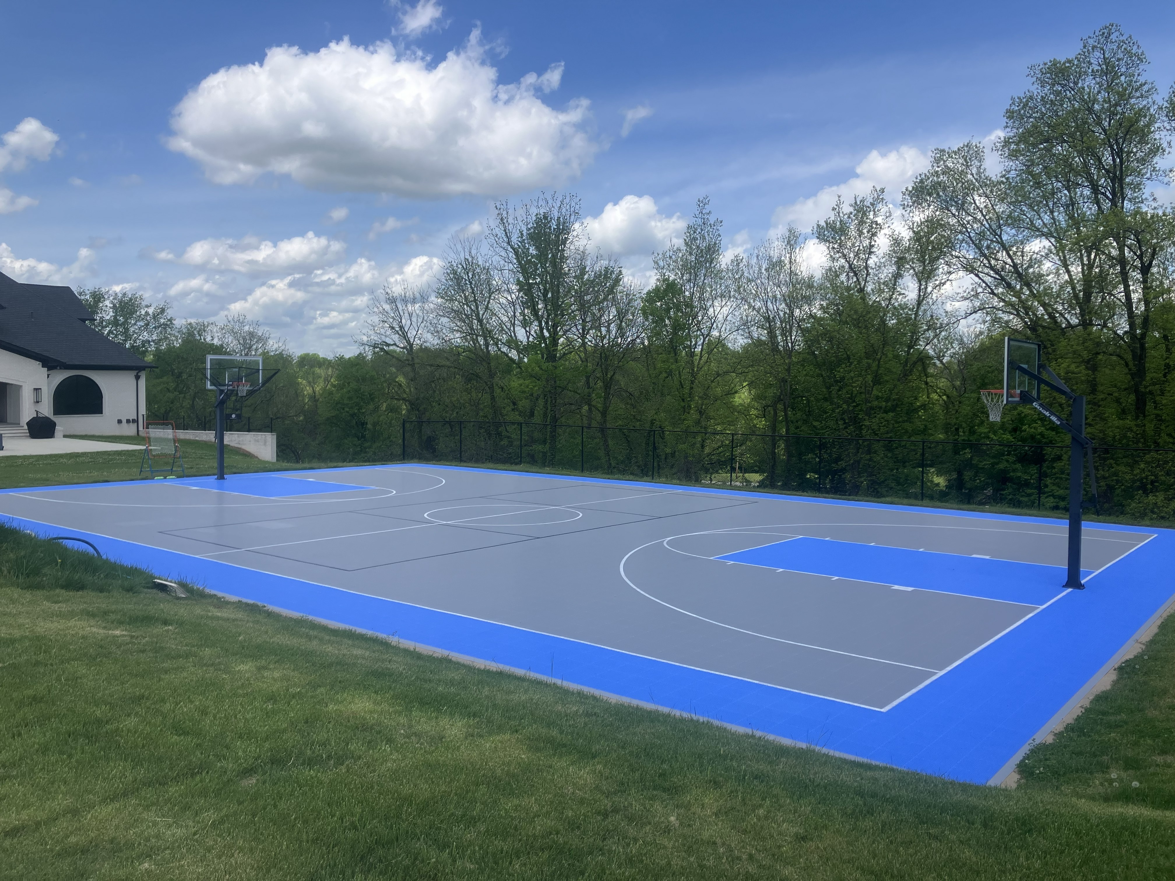 Large outdoor basketball court with bright blue borders.