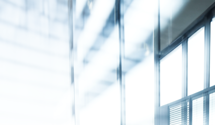 Des personnes dans une salle de réunion, vues d’une fenêtre.