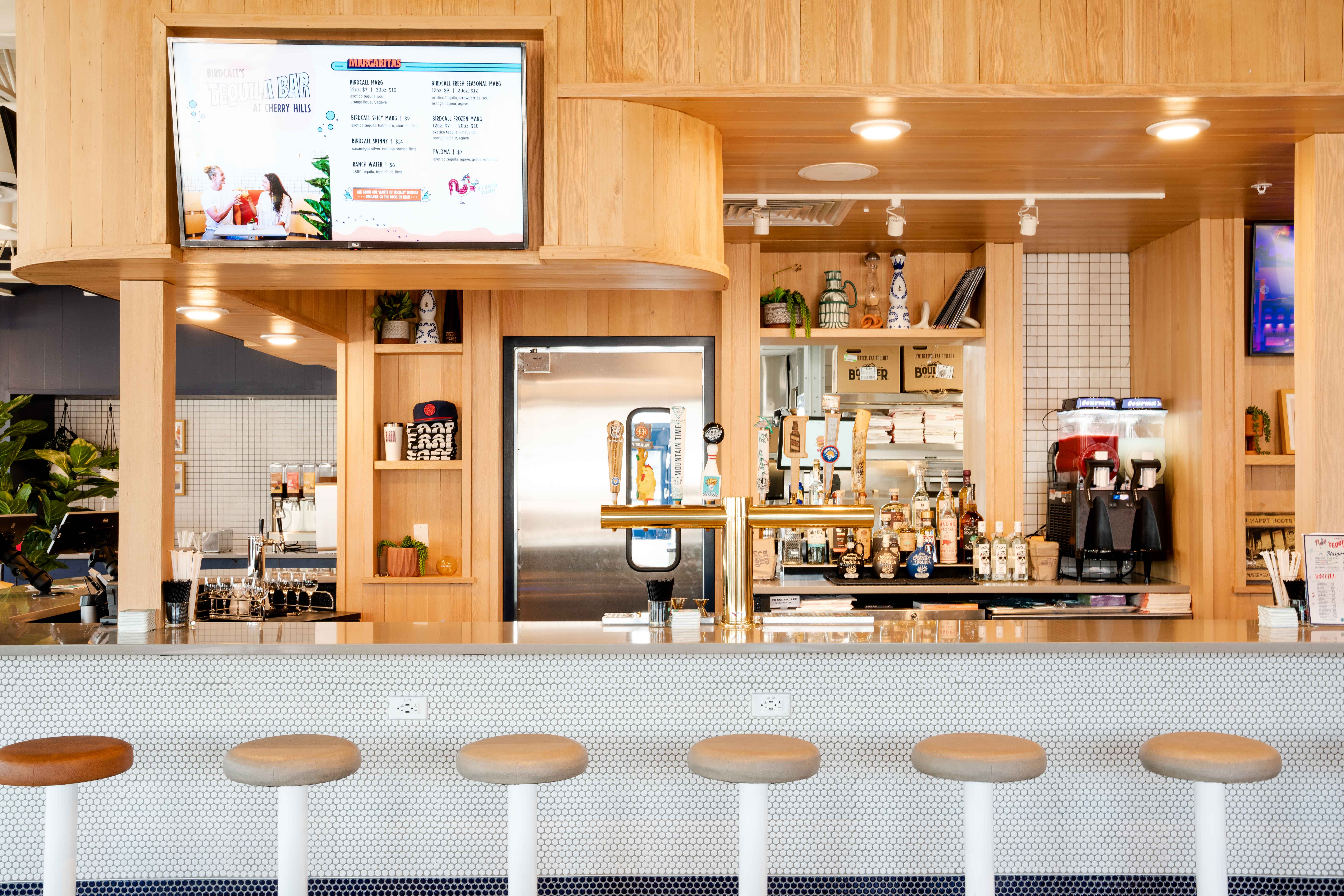 View of the bar at Birdcall Cherry Hills, showing off numerous beers on tap as well as frozen margarita options.