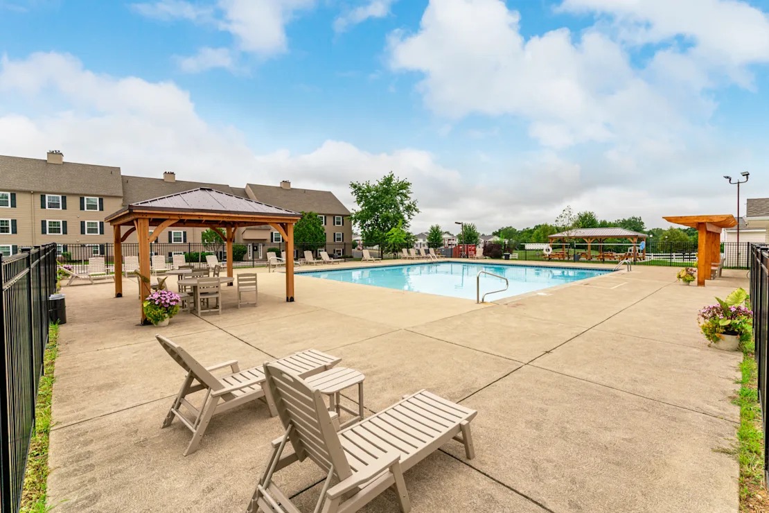 Outdoor pool area with a gazebo and loungers.