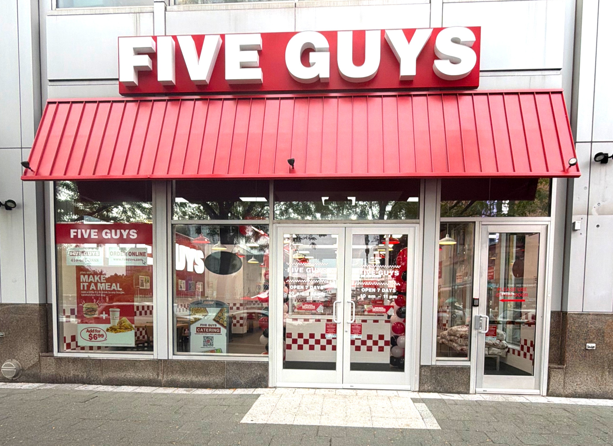 Exterior photograph of the Five Guys restaurant at 600 East Pratt Street in Baltimore, Maryland. 