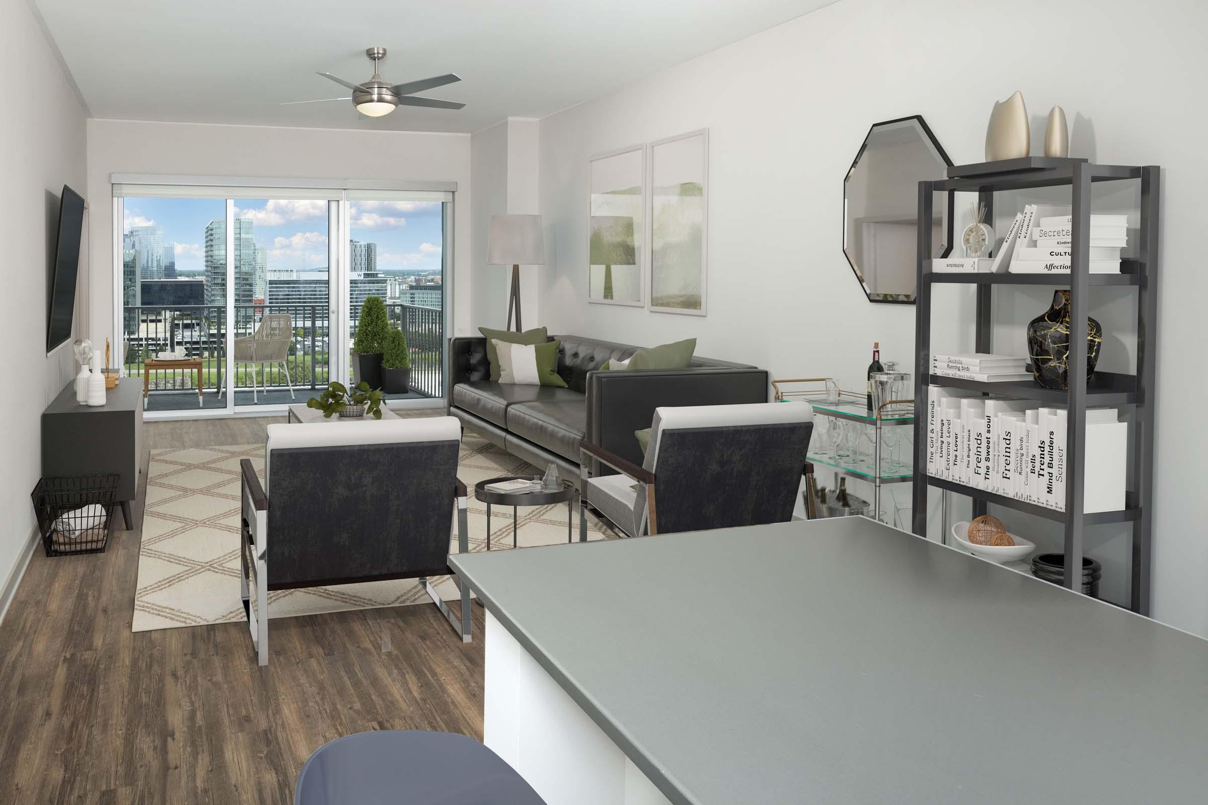 View from kitchen island into open-concept living room with balcony overlooking Downtown Nashville.