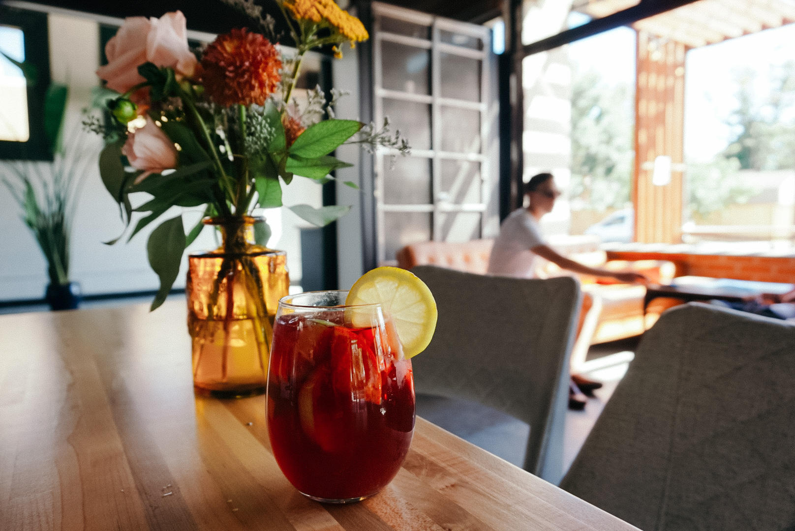 A glass of sangria sitting on the table with flowers. At The Radiator.