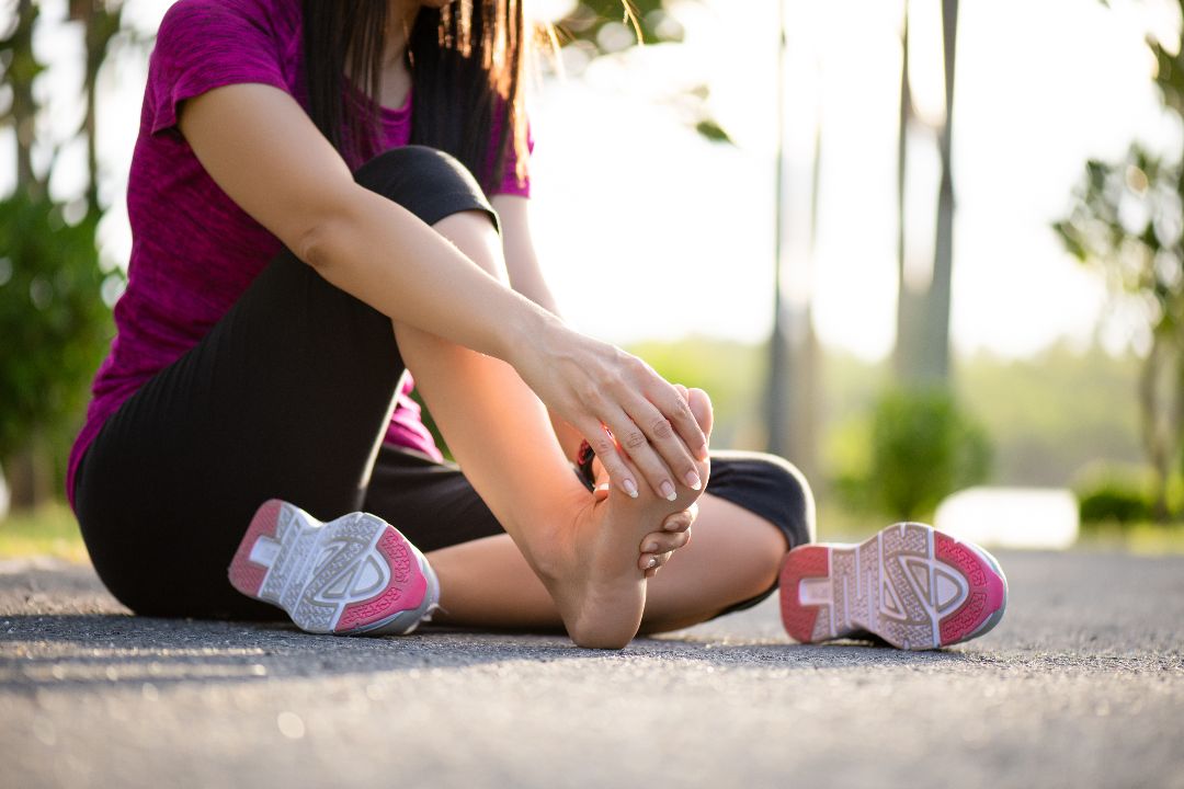 low-section-woman-with-foot-ache-sitting-road.jpg