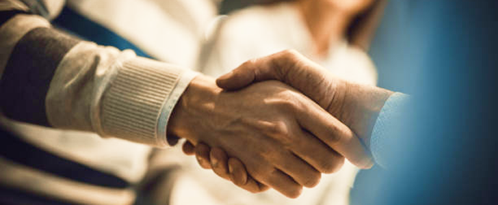 Close-up shot of people shaking hands.