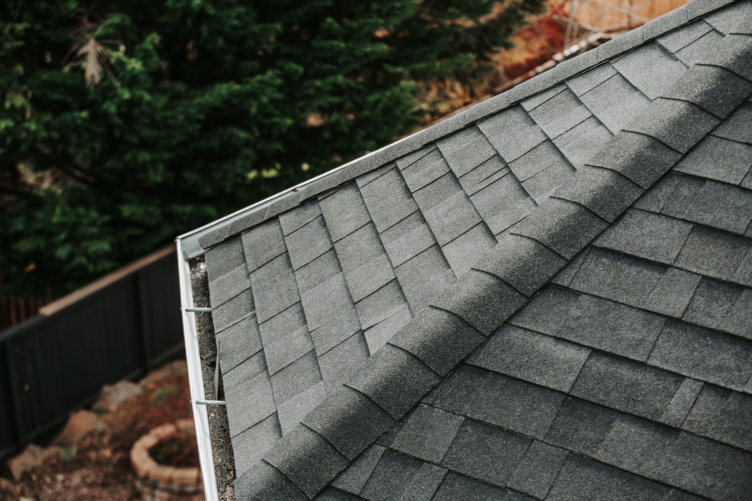 Close-up of architectural asphalt shingles installed along a residential roof slope. 