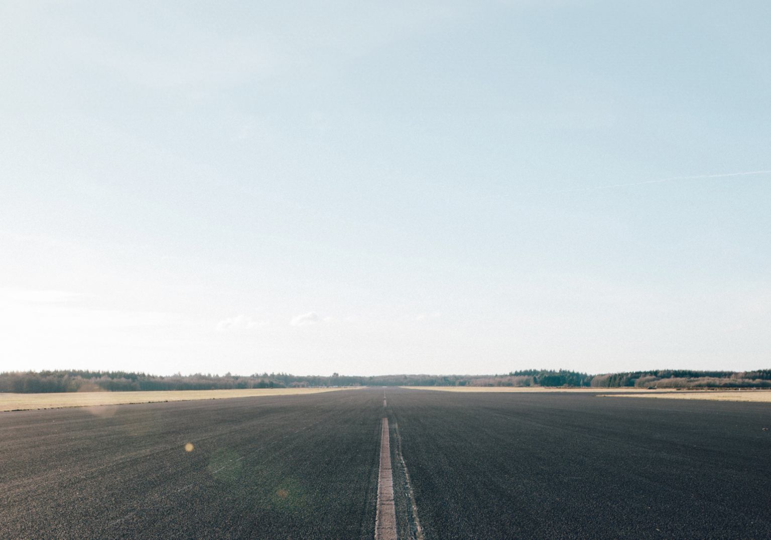 An open road surrounded by fields.