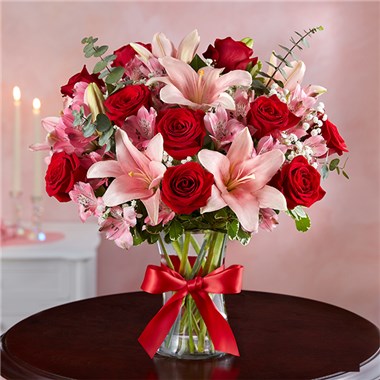 Let her know she’ll always hold the key to your heart with our magnificent Valentines arrangement. A show-stopping mix of radiant red & pink blooms, it’s hand-arranged inside a clear glass vase tied with a red satin ribbon.