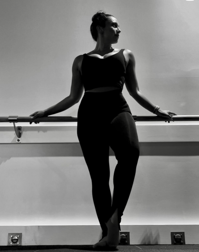 Woman resting at the ballet barre at Pure Barre Aventura studio, located at The Abbey at Aventura on Biscayne Blvd
