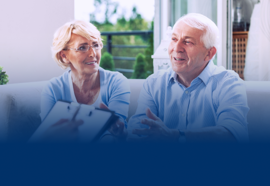 An older couple sitting on a couch, talking to advisor who is out of frame.