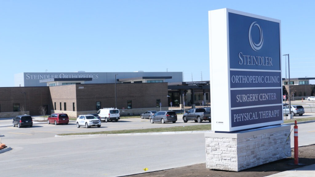 Exterior roadside sign identifying Steindler Orthopedic Clinic, Surgery Center, and Physical Therapy, located at the North Liberty medical campus, with the main building visible in the background.