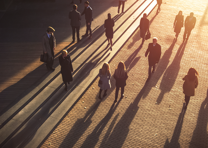 Une vue aérienne de gens d'affaires marchant dans le quartier financier au coucher du soleil.