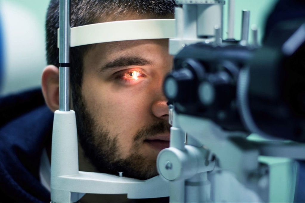 Man receiving an eye exam through a slit lamp