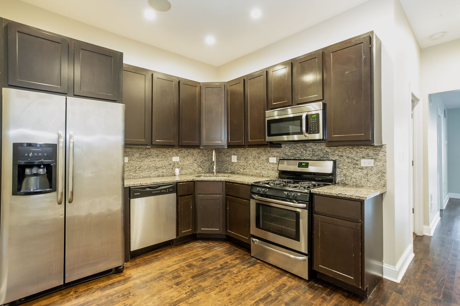 Upgraded kitchen with stainless steel appliances and recessed lighting at Invitation Homes Chicago.
