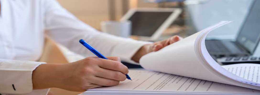 Close-up of a professional signing a document.