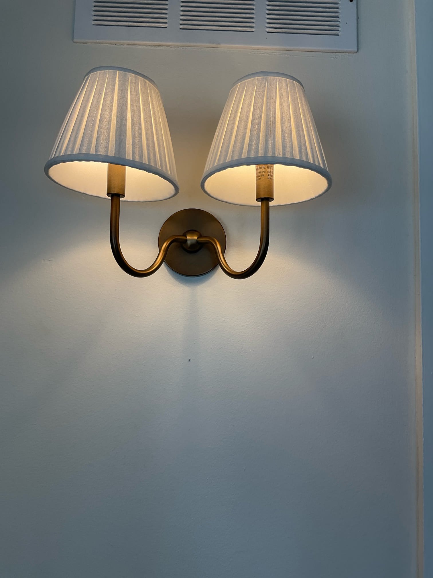 Thomas Edison Electric installed a two-arm brass wall sconce with pleated fabric shades in a Jenkintown, PA home. The classic design adds warm ambient light and an elegant touch to the room.