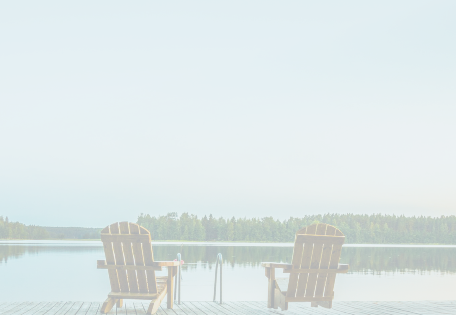 Two Muskoka chairs on a dock facing a calm lake.