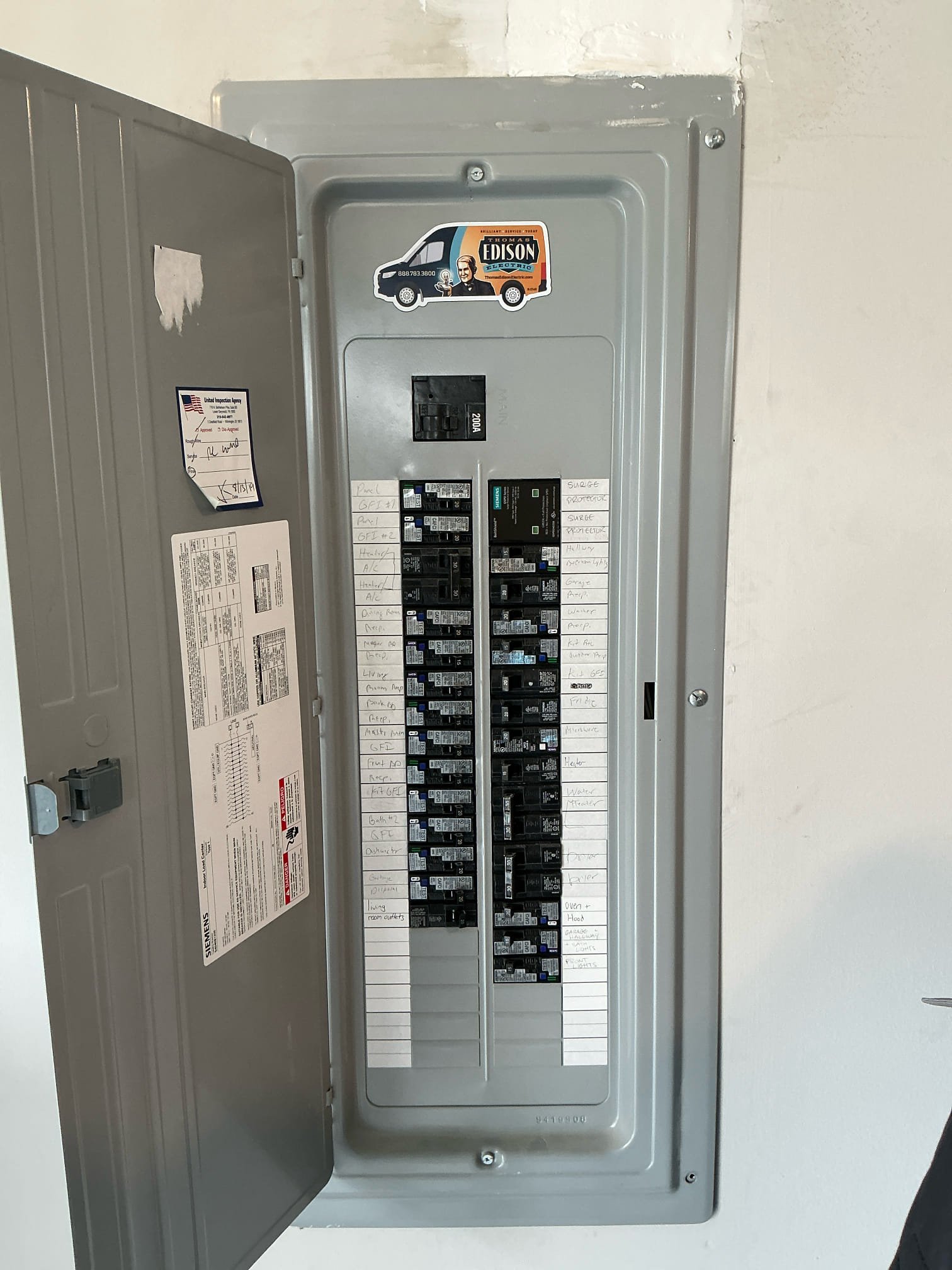 A Siemens 200-amp breaker panel installed by Thomas Edison Electric in a North Wales, PA home, complete with the company's branded van magnet on the panel door. Every circuit is labeled, and a United Inspection Agency sticker confirms the work passed local code review.