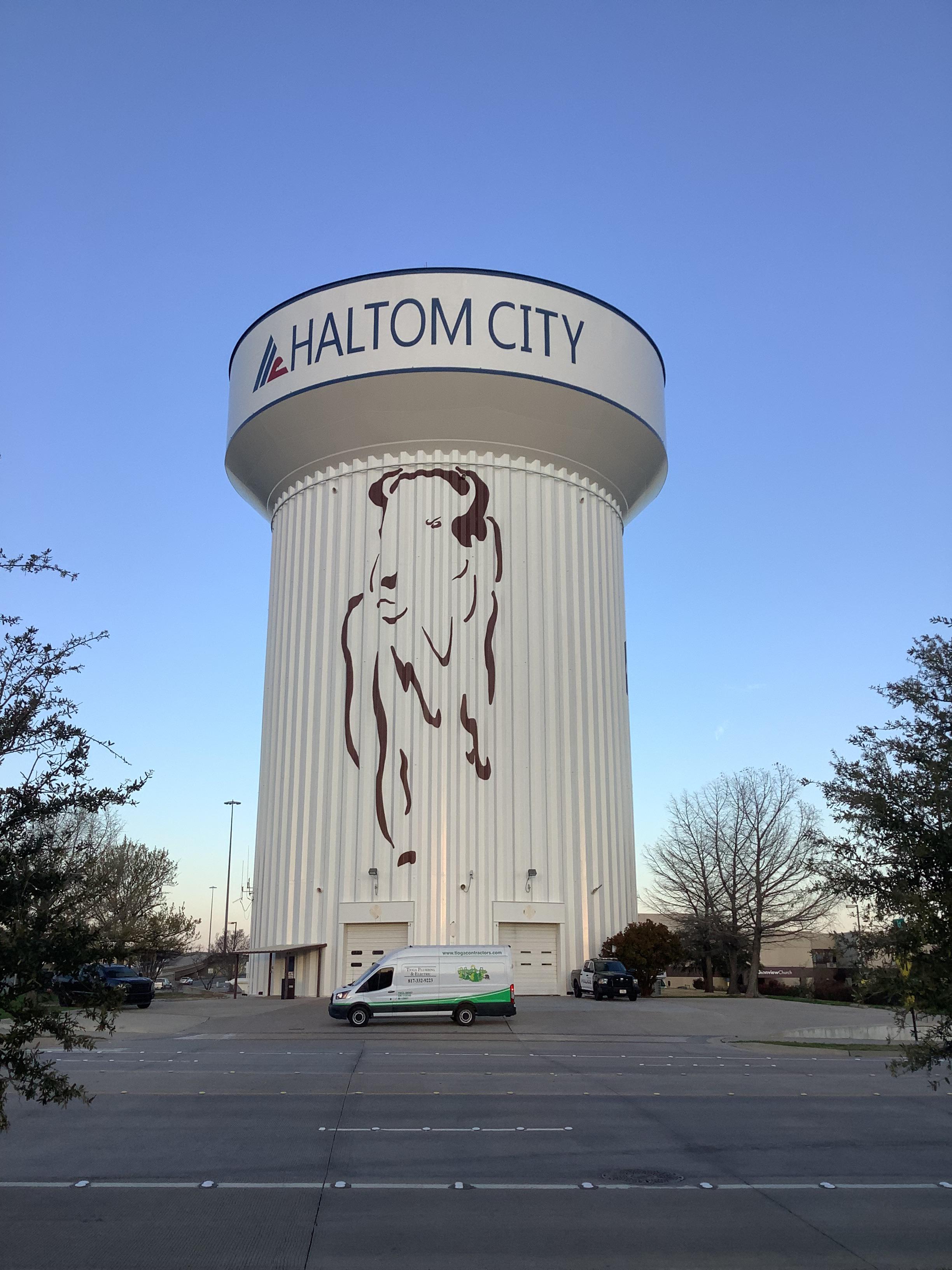 One of the Tioga service vans in front of a Haltom City water tower in Haltom City Texas.