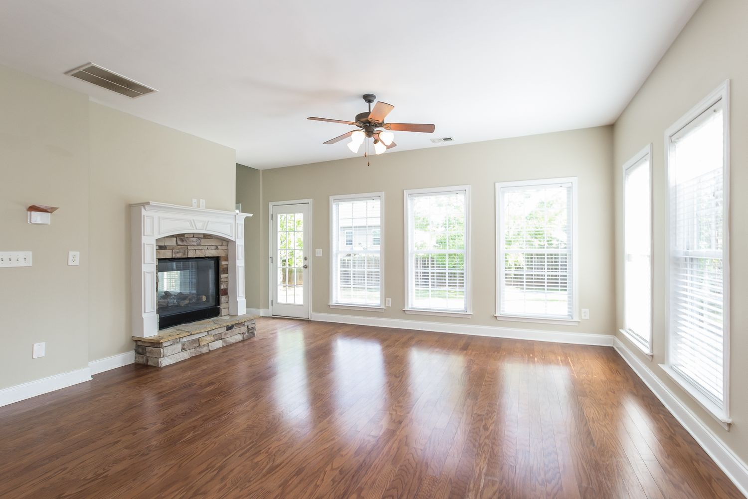 Stone fireplace with wood flooring at Invitation Homes Atlanta.