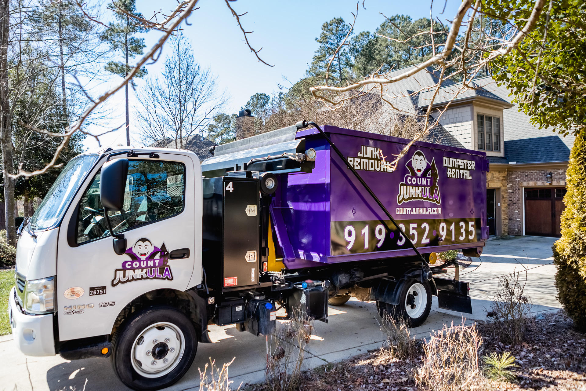 count junkula of raleigh branded dumpster in driveway