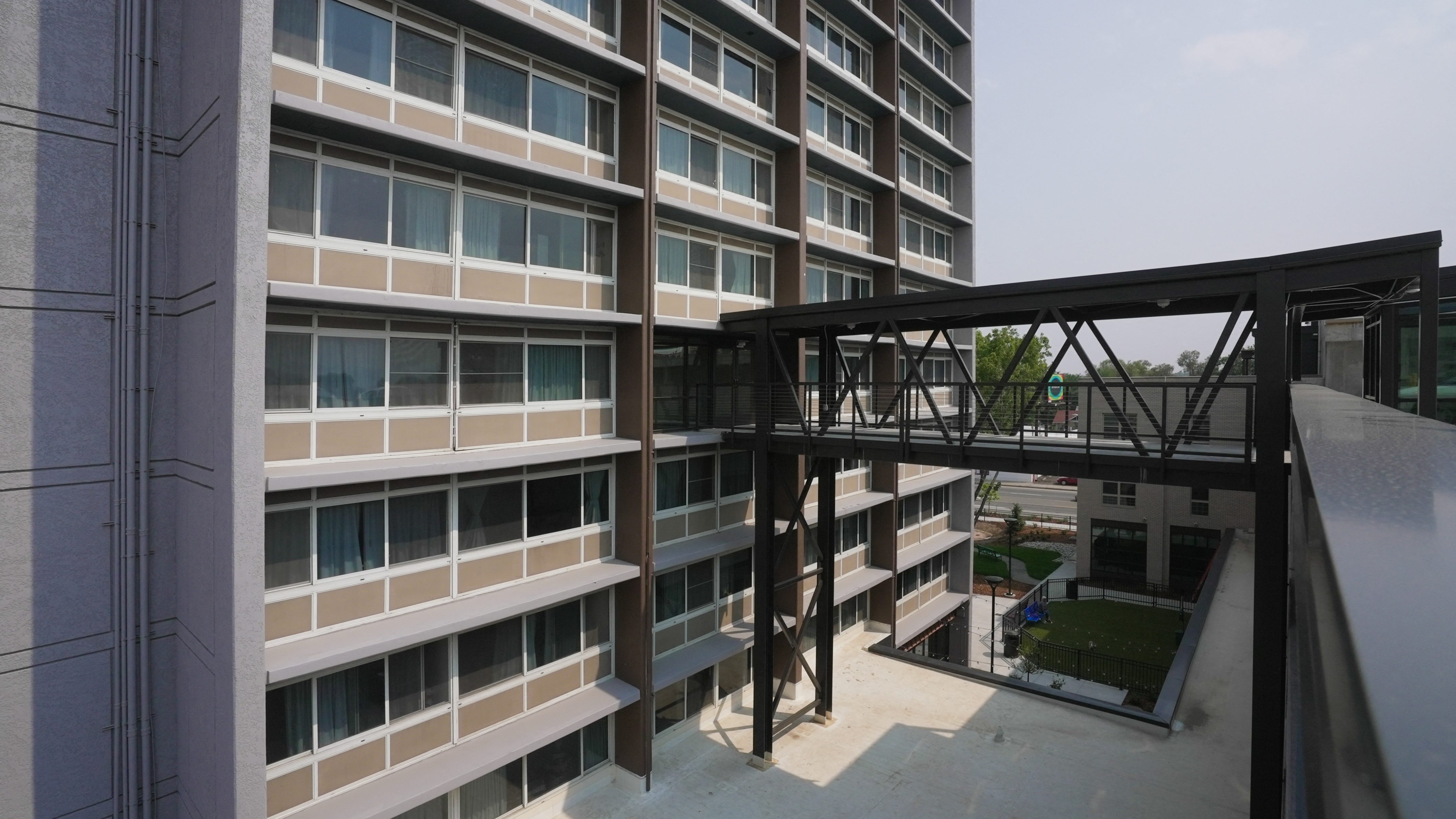 A modern building with a metal walkway connecting the floors