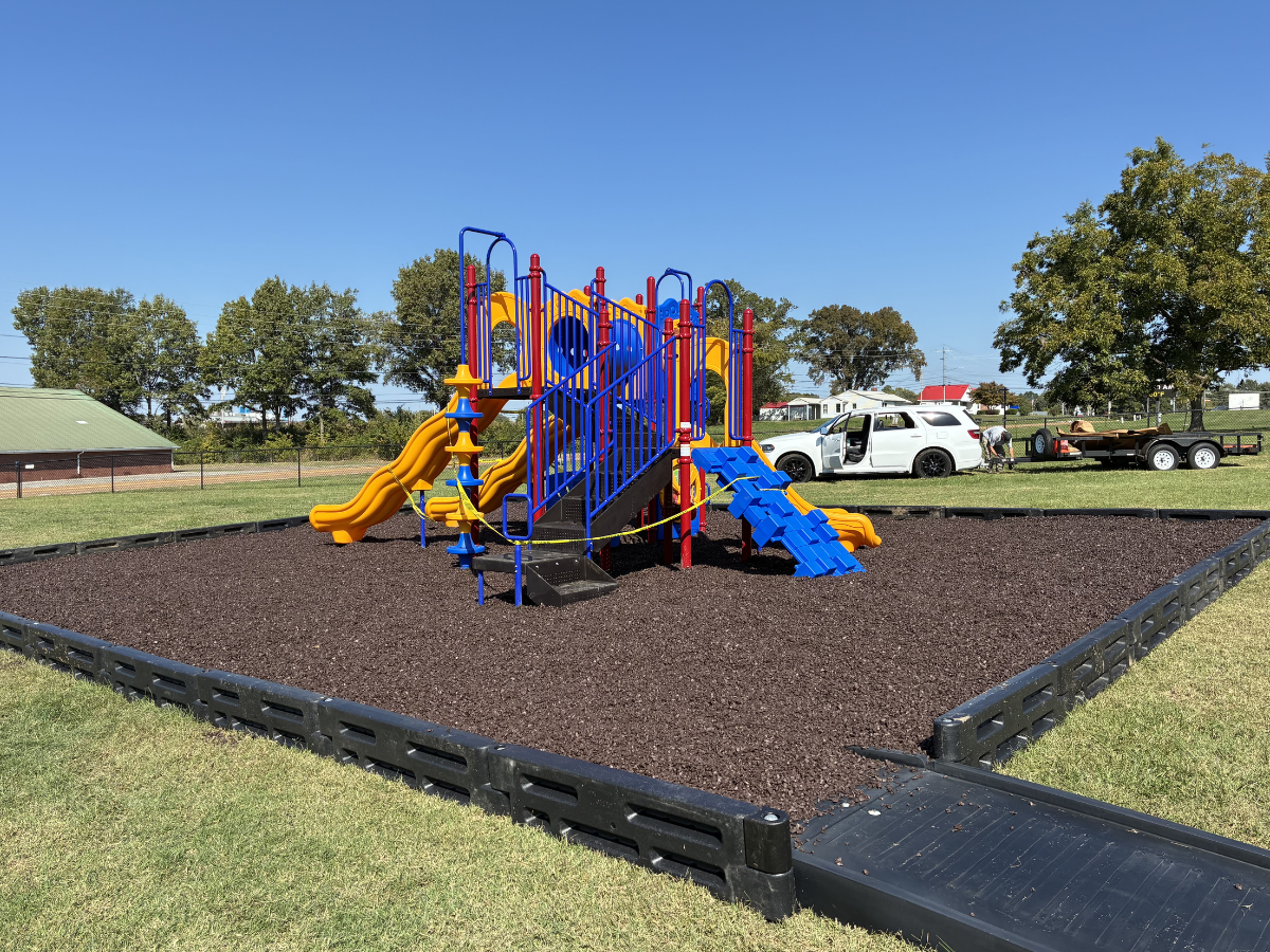Colorful commercial playground structure with yellow slides.