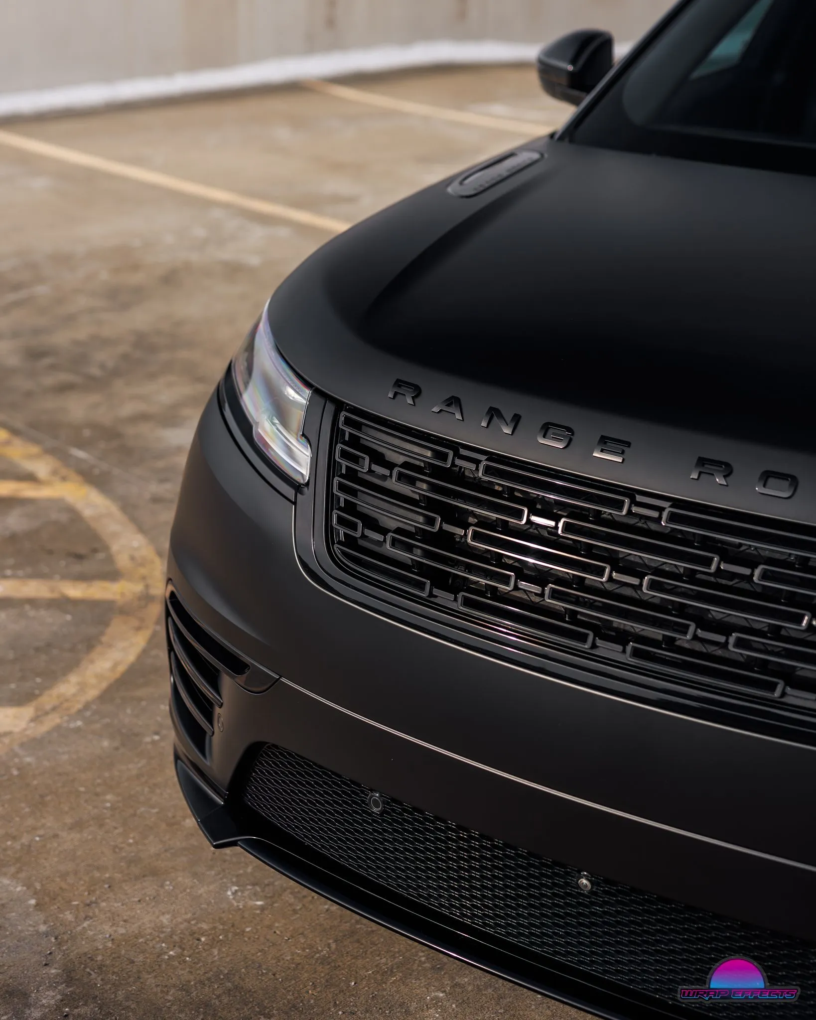 Matte black Range Rover front-end showcasing premium vinyl wrap, black grille, modern LED lighting, luxury styling, and flawless finish emphasizing sophisticated automotive customization and detailing craftsmanship.