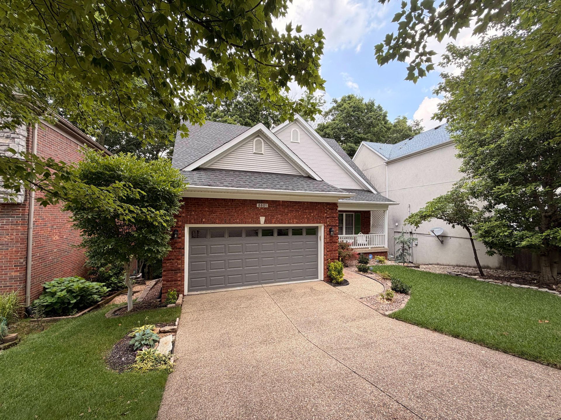 Residential property with a new gray shingle roof installed over the garage and main living areas, p 