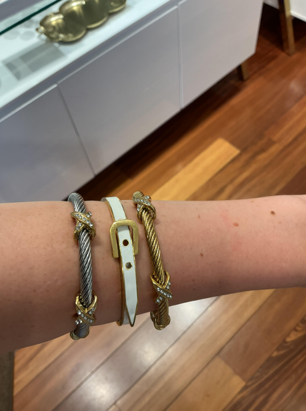 Explore bracelet styling at Eliana Curated with gold-tone and silver-tone twisted cuffs, sparkling accents and a white buckle bracelet. This layered combination adds a polished touch to daily outfits.